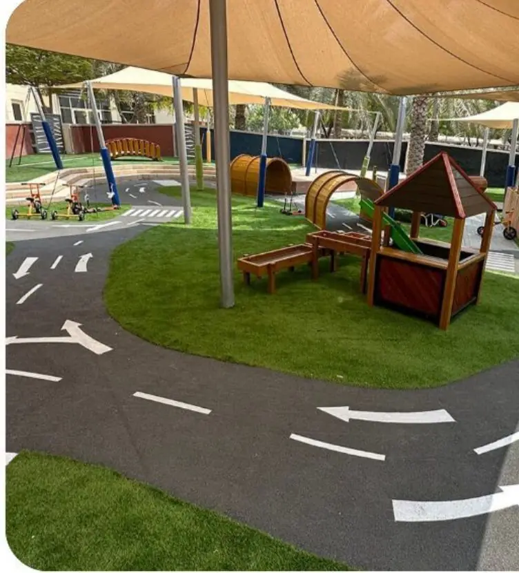 Children playing on a shaded commercial playground installed by Terrain Play in the UAE